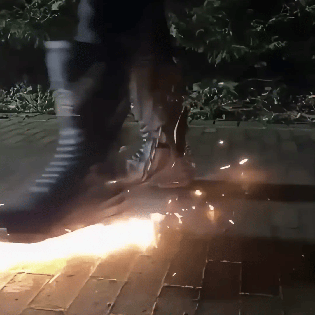 Riding boot on asphalt with sparks trailing from the heel plate